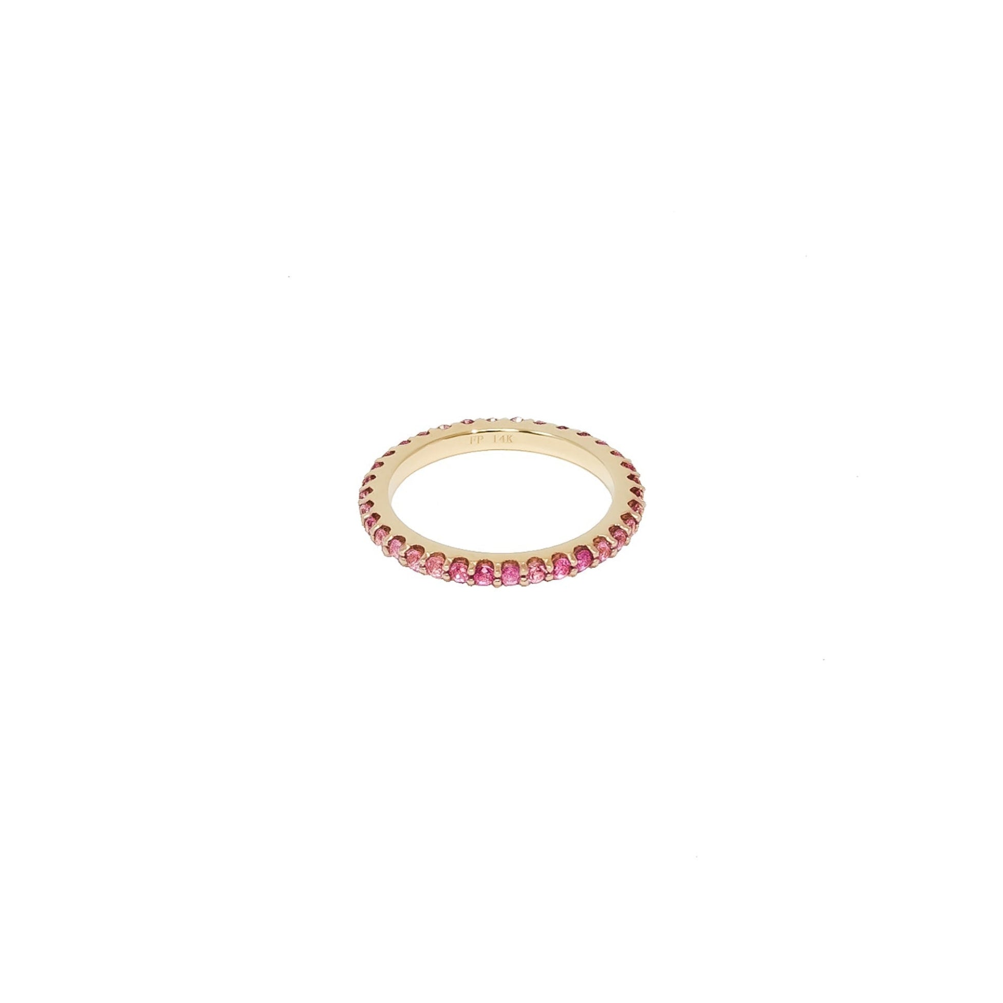 A gold eternity ring featuring a full beaded border of small pink gemstones, shown on a plain white background.