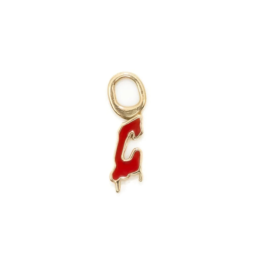 Gold charm with red letter 'C' on a white background