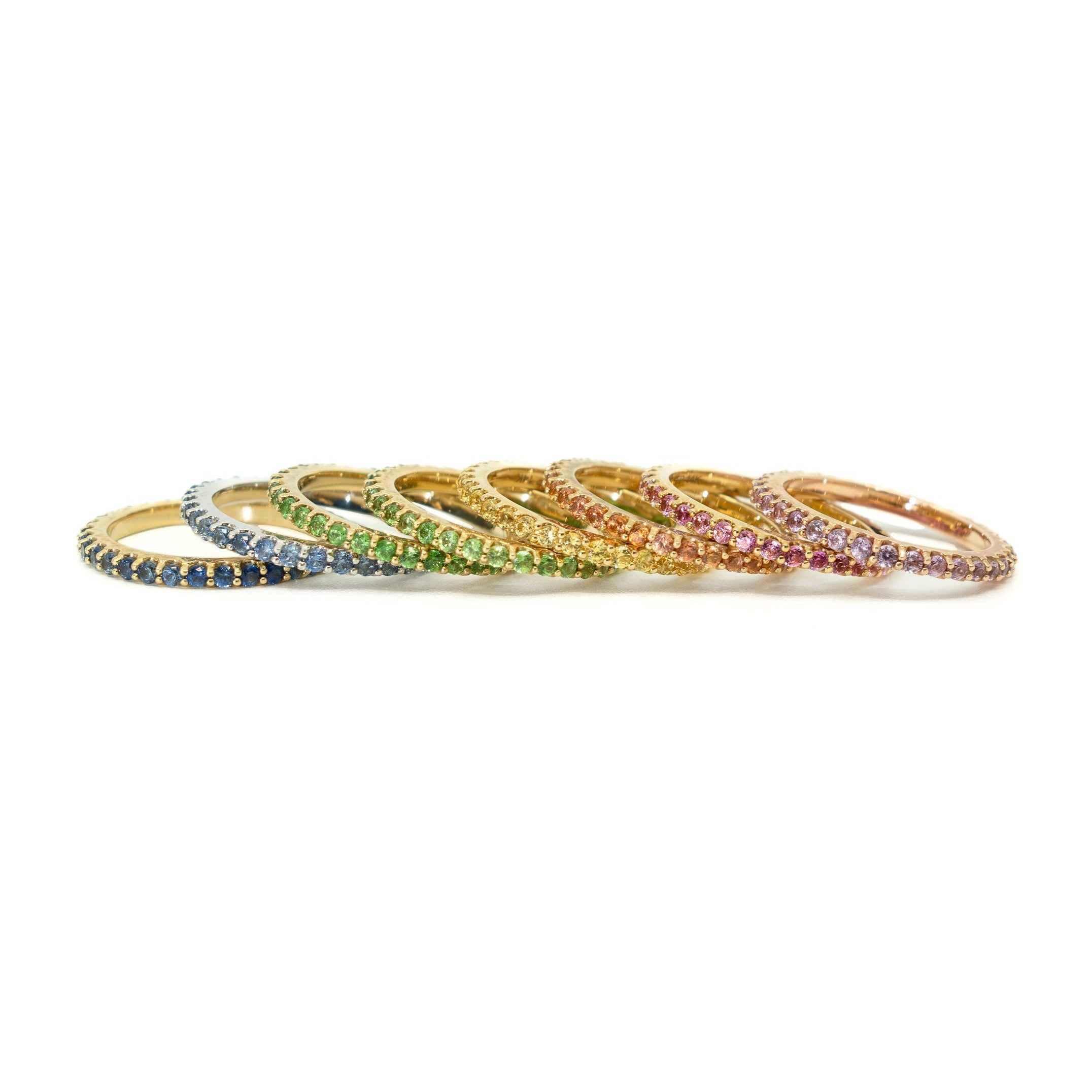 Set of colorful gemstone rings on a white background