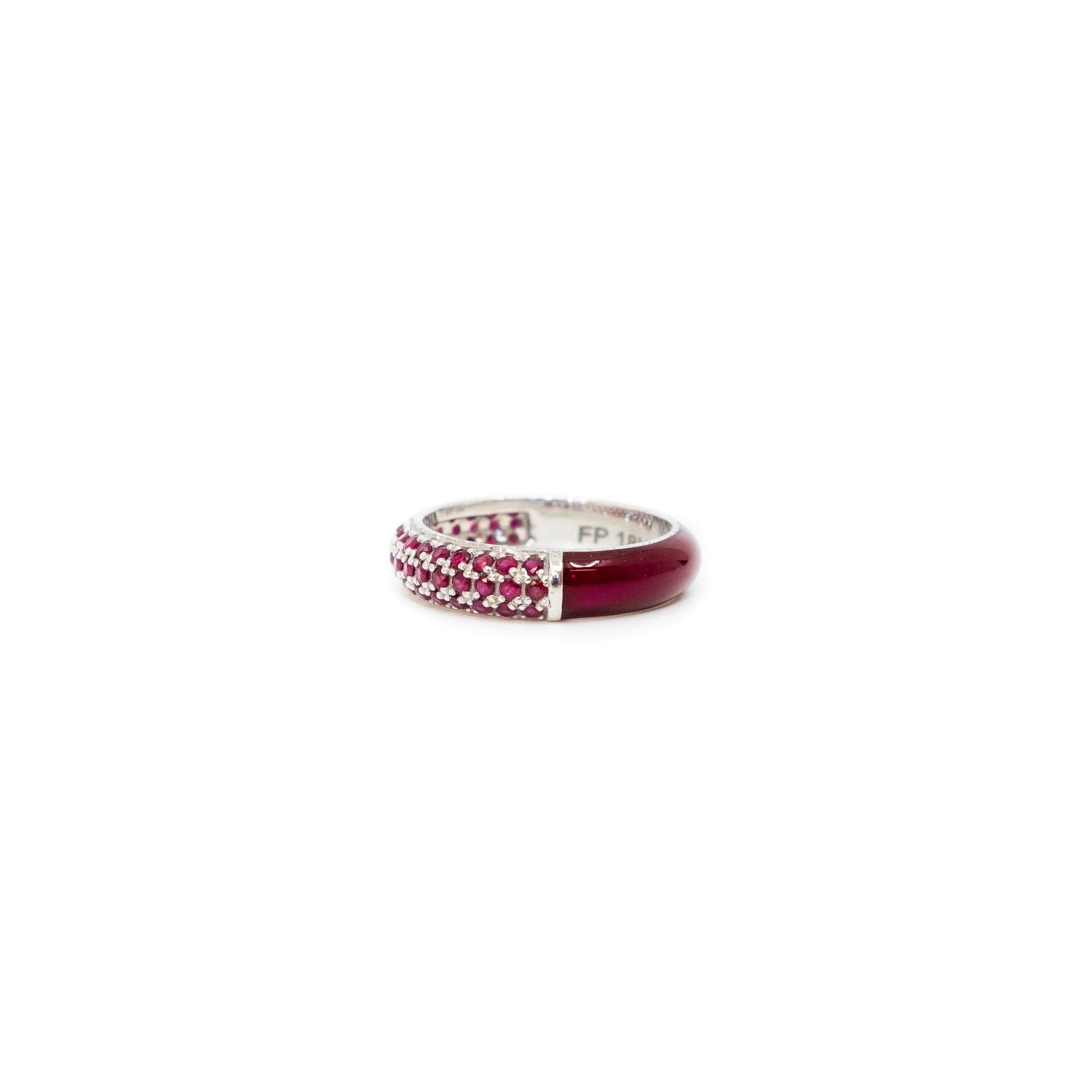 A 18K gold wide split pave enamel stacking ring with a round cut red gemstone in the center, set in a white band.