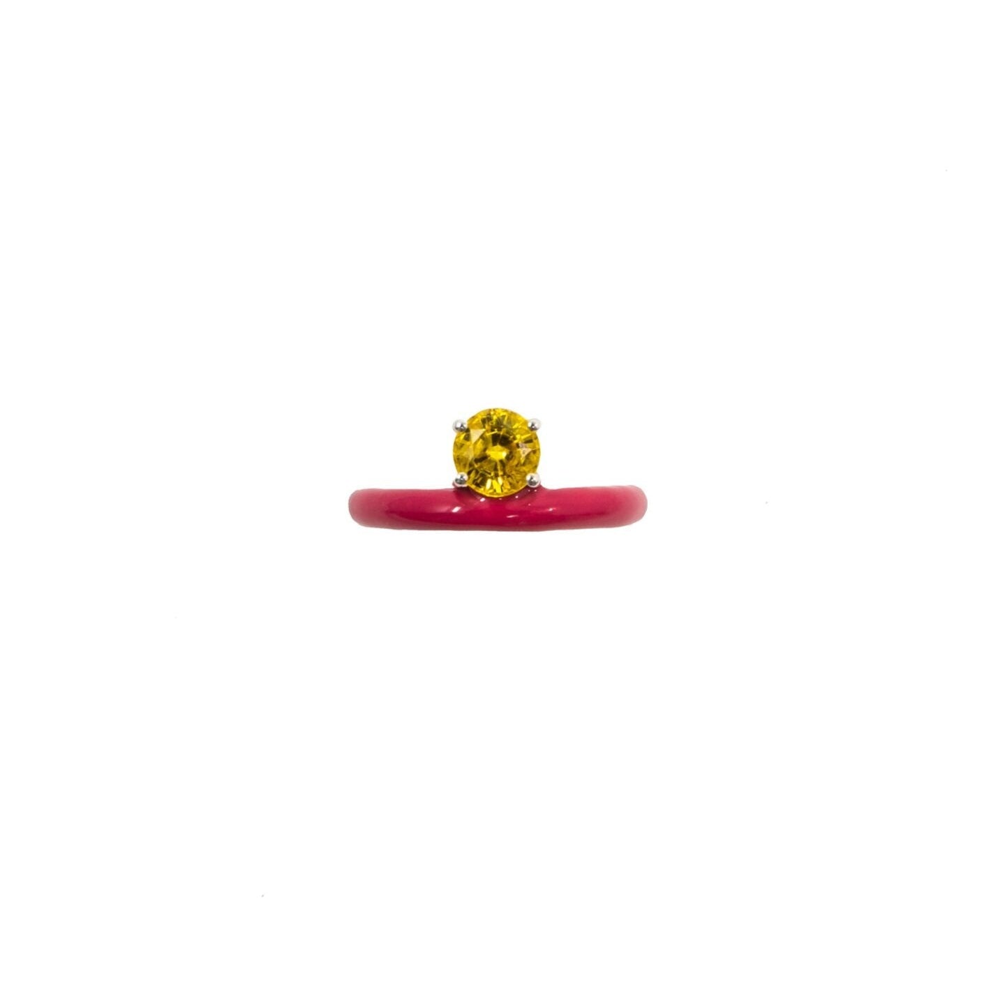 A thin band stacking ring with a fuchsia enamel and a yellow citrine round cut gemstone in the center.
