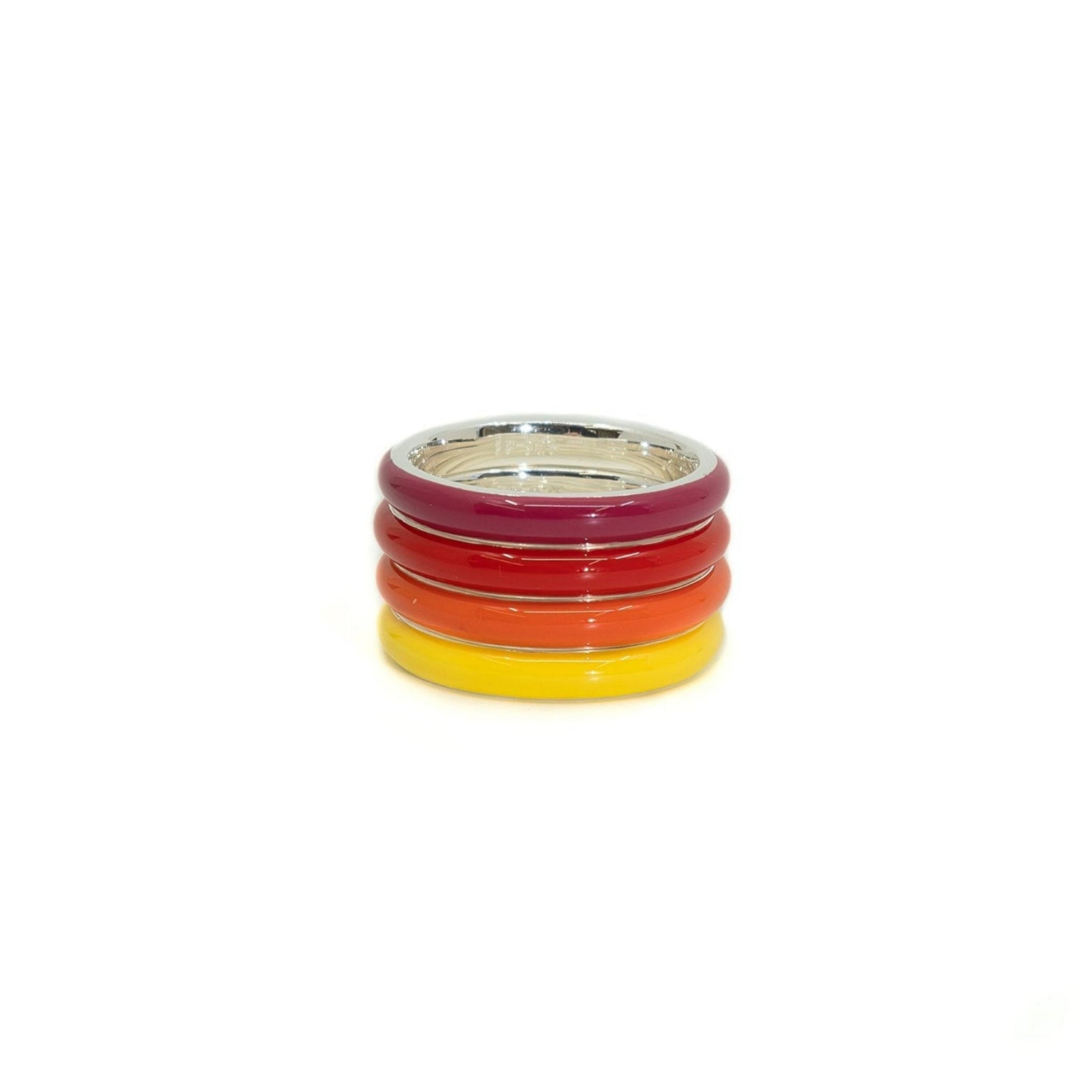 A stack of four thin enamel stacking rings in fuchsia, really red, florida orange, and sunshine yellow colors.