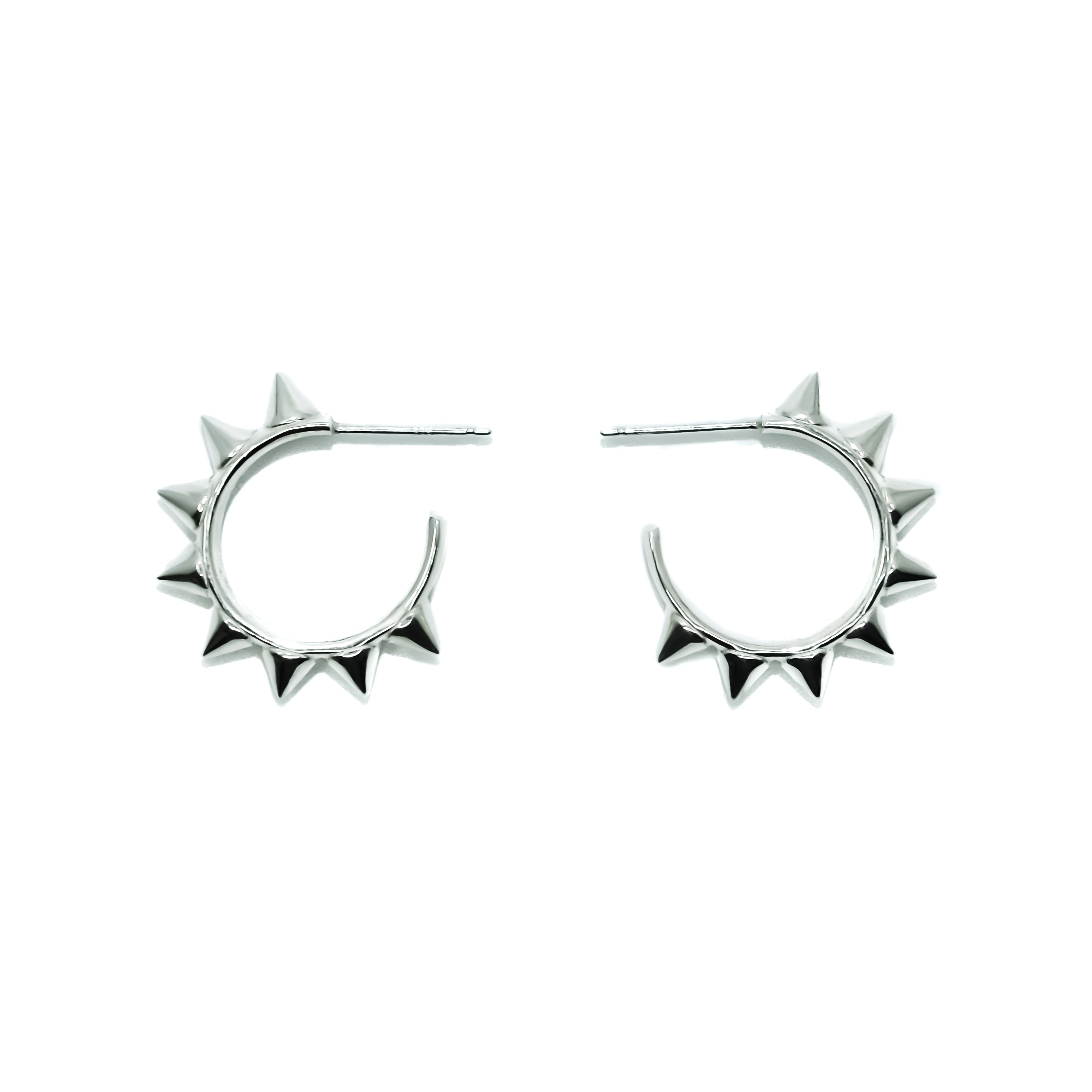 Silver hoop earrings with spike details on a white background