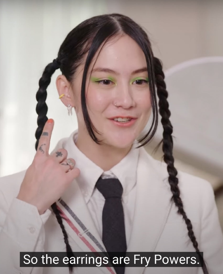 Michelle Zauner pointing to FRY POWERS earrings during Vogue’s 7 Days, 7 Looks video.