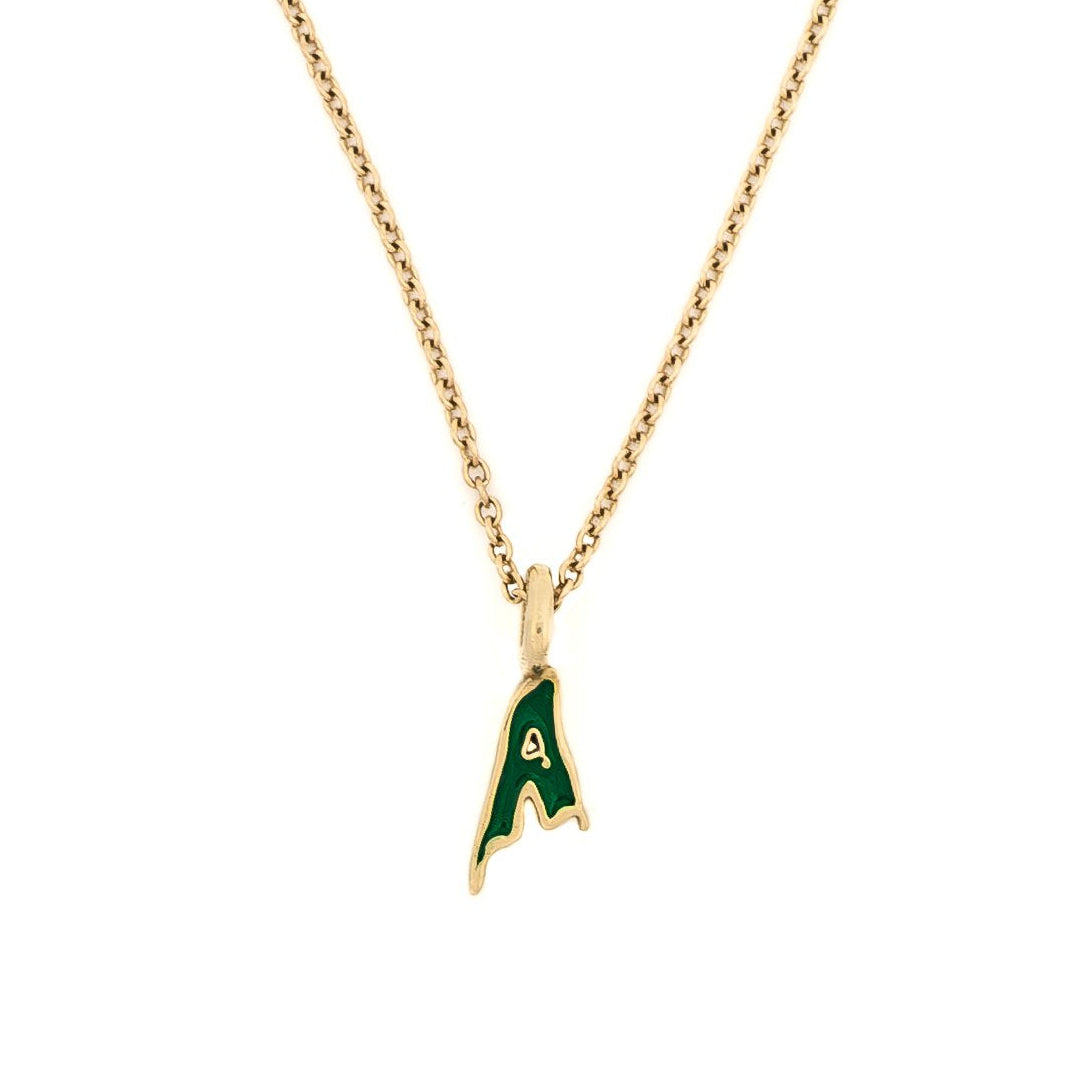 A gold-colored pendant necklace with an eerie design featuring an initial, possibly the letter 'A' in a stylized font, on a chain.