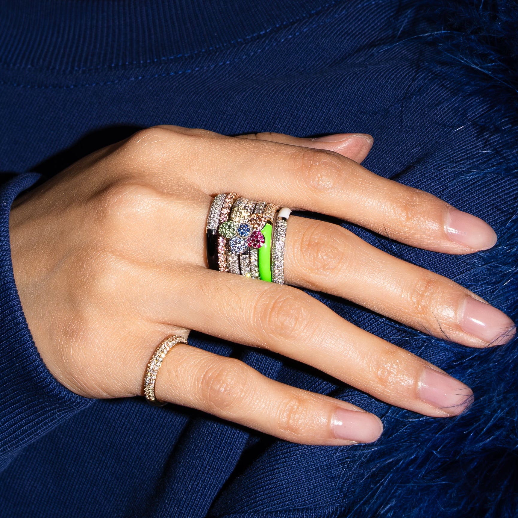 Hand with rings wearing a blue sweater