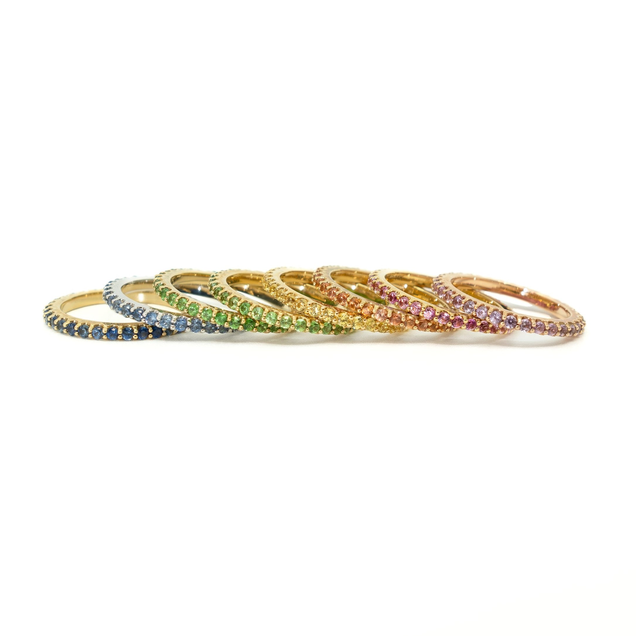 Set of colorful gemstone rings on a white background